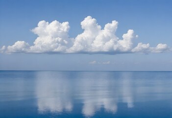 Naklejka na ściany i meble Calm blue ocean with white clouds reflected on the water surface