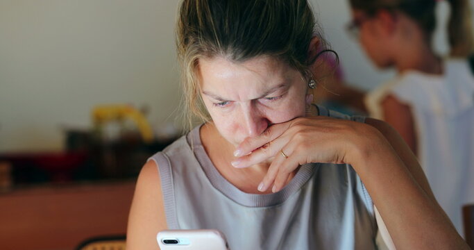 Concerned woman looking at cellphone screen real life candid woman worried reading information