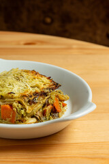 A close-up shot of a hearty vegetarian lasagna, with layers of fresh pasta, rich tomato sauce, melted cheese, and a variety of vegetables. 