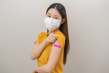 Healthcare of corona virus vaccination, happy asian young woman hand gesture showing strong with bandage, plaster on arm, getting vaccine immunity, giving injection influenza to protection pandemic.
