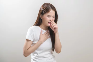 Tuinposter Female unhealthy Sickness, asian young woman, girl unwell and coughing, have cold, sore throat isolated white background suffering with symptom cough feeling bad. Healthcare of Coronavirus, covid-19. © KMPZZZ