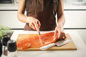 Women hold a raw salmon fillet