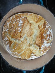 A close-up of beautifully cooked fresh artisan bread cooling in a Dutch oven