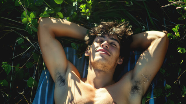 Beau jeune homme muscl&eacute; faisant la sieste en plein soleil en &eacute;t&eacute;.