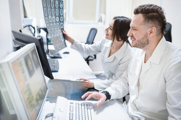Doctors in the MRI room sit at a computer monitoring the progress of the procedure. A council of doctors examines an MRI image. Blurred image	