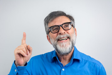 Mature handsome man with beard wearing casual shirt and glasses over grey background Smiling...