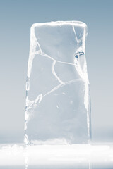 Crystal clear frosty textured natural ice block with cracks on shining mirroring glossy surface.
