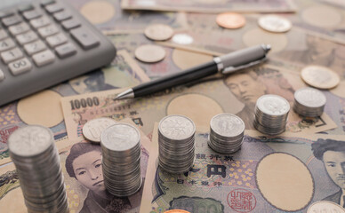 Background image of Japanese money scattered on the table in full screen. Overlaid coins...