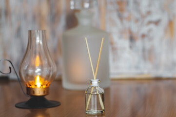 Decorating, h?gge and aromatherapy concept - scented reed diffuser, burning candle