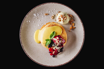 pancakes with berries and jam on a white plate