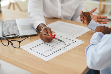 Close up cropped portrait of interior designer african american woman showing her client floor plan...