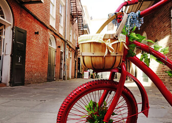 Funky red painted bike in the New Orleans French Quarter - obrazy, fototapety, plakaty