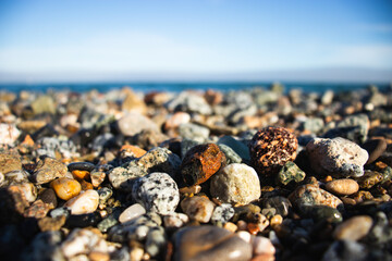Llevant beach, Barcelona, Spain, on a sunny day, waves and sea, blue sky, sand, pebbles and rocks,...