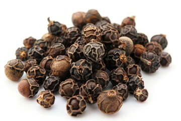 Obraz premium A pile of black pepper seeds on a white surface. Suitable for food and spice concepts
