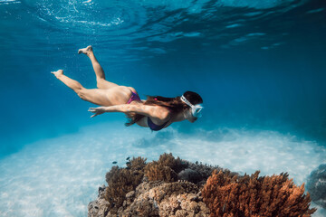 Woman with mask dives in transparent blue sea. Snorkeling with beauty lady in Hawaii