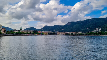 Obraz premium Panoramic view from a boat of city and lake of Como, Lomardy, Italy, Europe. Yachting on alpine mountain lake in the Italian Alps in summer. Living luxury life style, architecture and travel concept