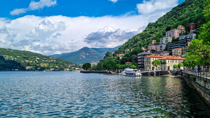 Fototapeta na wymiar Panoramic view from a boat of city and lake of Como, Lomardy, Italy, Europe. Yachting on alpine mountain lake in the Italian Alps in summer. Living luxury life style, architecture and travel concept