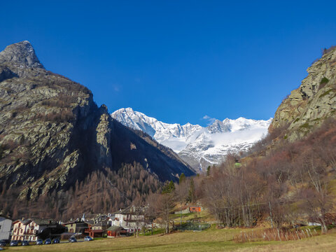 View from centre of tourist resort of Courmayeur from Dolonne, Courmayeur, Aosta Valley, Italy, Europe. Snow capped mountain range of Monte Bianco (Mont Blanc) in background. Italian French Alps