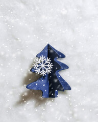 Hand made Christmas, New Year decor. One Blue Christmas tree cut out of craft paper with snowflake, snow on white fur. Cute winter homemade decorative creative ideas. DIY decor, authentic, copy space