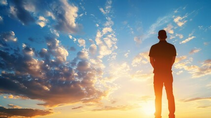 Silhouetted man standing under majestic sunset sky full of clouds