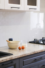 Fototapeta na wymiar Home kitchen interiorBowl with dough, eggs and bowl of sugar on kitchen table in modern kitchen.