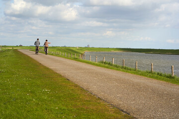 National Park in Holland. Landscape in spring on a sunny day. Cyclists on dam Netherlands, Zeeland,...