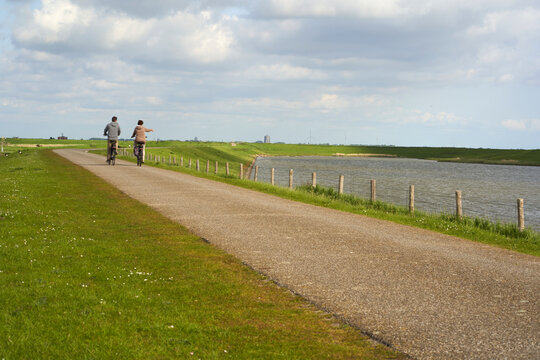National Park in Holland. Landscape in spring on a sunny day. Cyclists on dam Netherlands, Zeeland, Oosterschelde.