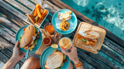  Fast food for summer holiday. Sandwiches and chips, fresh vegetables on wooden background for snack by the sea on the beach.	