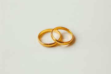 Obraz na płótnie Canvas Two gold wedding rings lie laconically on a white background