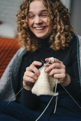 Smiling woman at home enjoy resting home leisure activity sitting on the floor near sofa - female people knitting. People inner lifestyle hobby