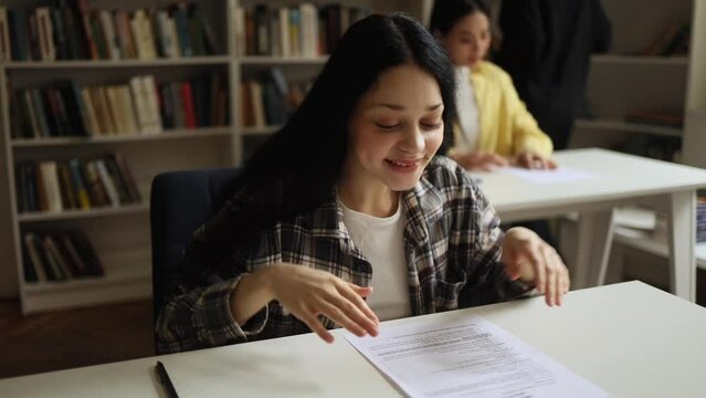 Portrait of happy student got an excellent grade mark for the test at university class Cute smiling girl looking at test in good mood indoors Exam passed Successful education concept