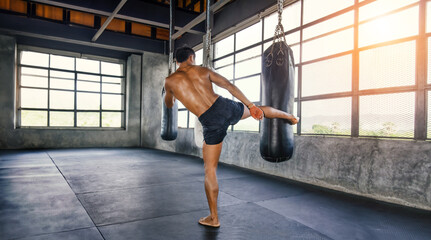 Muay thai fighter training in gym with punching bag