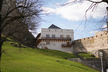 View of a Trencin castle yard with greed grass lawn and old buildings