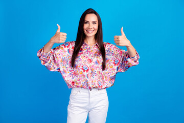 Photo of confident cheerful lady dressed print blouse showing two thumbs up isolated blue color...