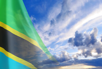 Flag of Tanzania on background of cloudy blue sky. Concept of National Holidays
