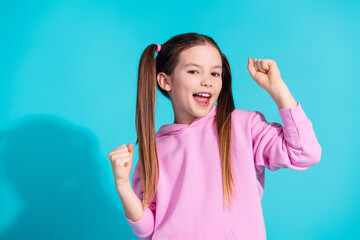 Photo portrait of lovely little girl winning dressed stylish pink garment isolated on aquamarine...