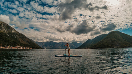vibrant SUP paddleboarding group enjoying the serene waters against a backdrop of majestic...