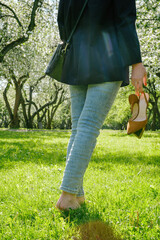 woman walking barefoot on green grass