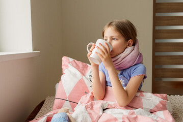sick little girl with a cup of hot tea.