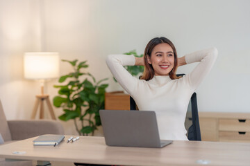 Happy woman sitting at work feeling relaxed at home