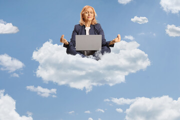Businesswoman with a laptop computer sitting in a meditation pose on a cloud