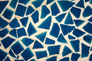 Fototapeta premium A blue and white mosaic tile pattern with blue tiles. The blue tiles are cut into small pieces and arranged in a way that creates a unique and interesting design. Scene is one of creativity