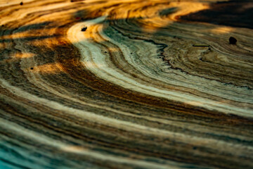 A wooden surface with a wavy pattern. The wood appears to be aged and has a rustic feel to it. The...