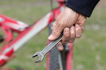 Bicycle repair.A man repairs his bicycle in a spring park.