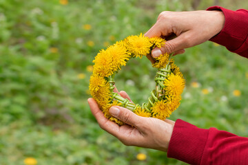 Yellow dandelions and a man.A girl holds a wreath of dandelions in her hands.Spring theme.