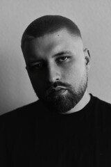 Portraits of a Millennial guy with a short haircut and beard, earrings in his ears