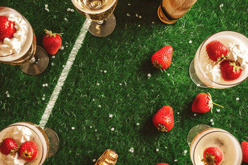 Champagne with strawberry symbolizes triumph and achievement. Celebration on sports field shows dedication and hard work that led to victory.