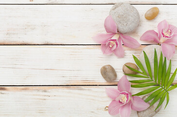Composition with orchids and massage stones on wooden background, top view
