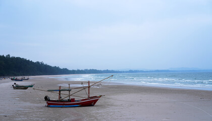 A view of small traditional fishing boats moored up on sandy beach in Chumphon Province, Thailand.