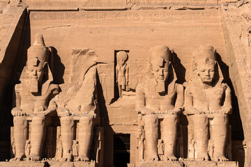 Abu Simbel, Egypt: Exterior view of the majestic statues of Ramses II that ornate the facade of the famous Abu Simbel temple in Upper Egypt. - obrazy, fototapety, plakaty